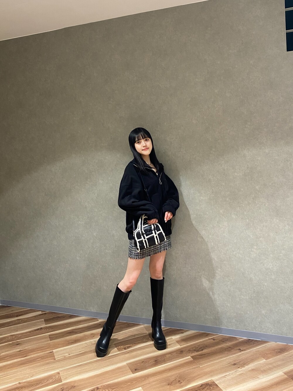 ブラック系のブルゾン、ブラック系のブーツ、ブラック系のハンドバッグを着用したレディースの秋コーディネートの2枚目の写真