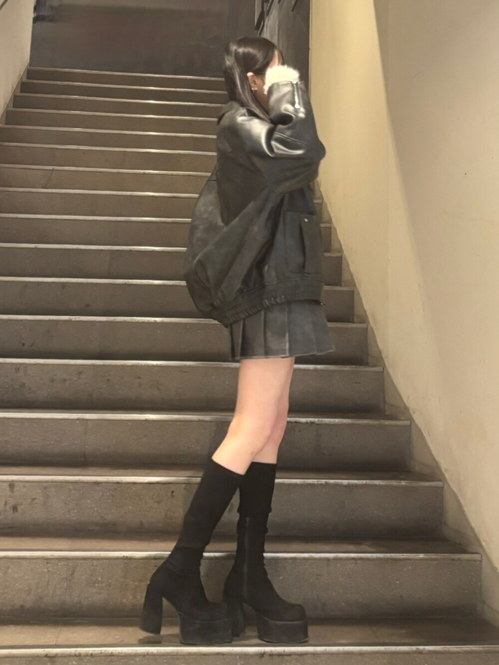 グレー系のスカート、その他のブーツ、ブラック系のブルゾンを着用したレディースの冬コーディネートの2枚目の写真