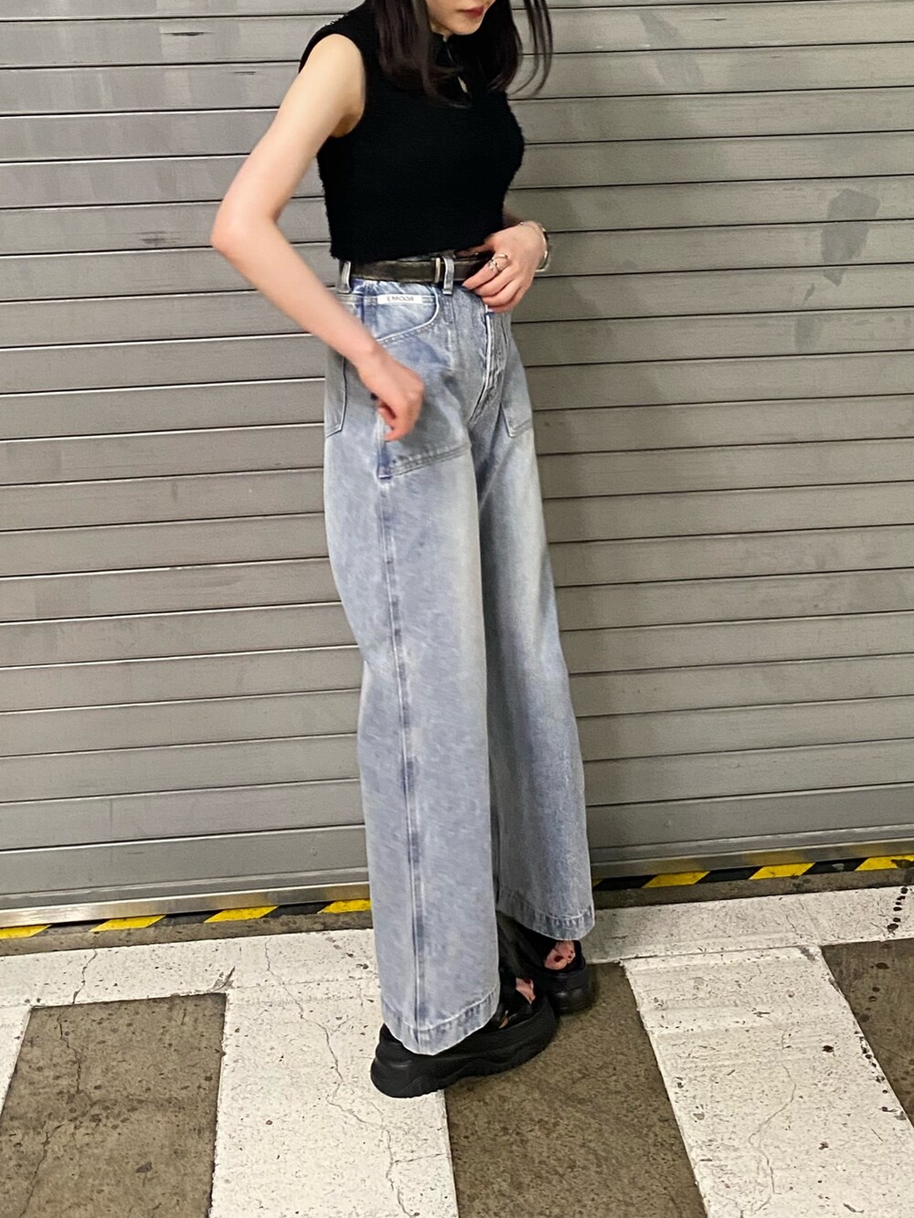 ブラック系のサンダル、ブラック系のニット/セーター、ブラック系のデニムパンツを着用したレディースの夏コーディネートの2枚目の写真