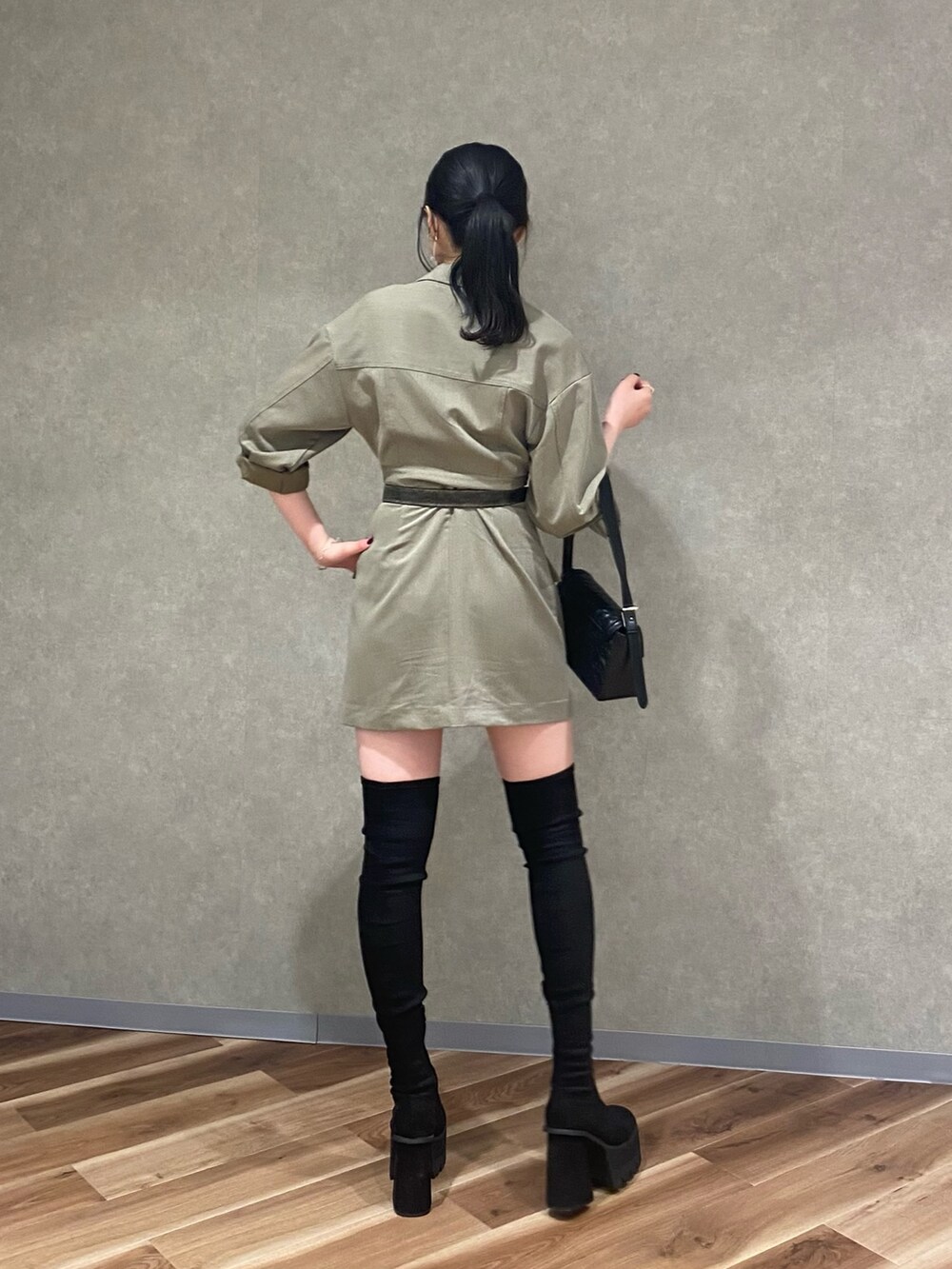 ブラック系のブーツ、ブラック系のハンドバッグ、ベージュ系のワンピースを着用したレディースの秋コーディネートの3枚目の写真