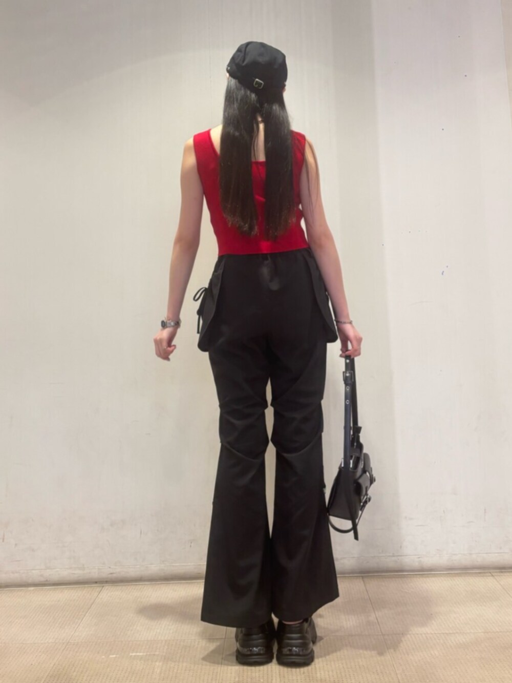 ブラック系のハンドバッグ、ブラック系のその他パンツ、レッド系のTシャツ/カットソーを着用したレディースの夏コーディネートの3枚目の写真