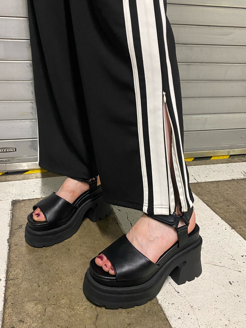 オレンジ系のTシャツ/カットソー、ブラック系のその他パンツ、ホワイト系のハンドバッグを着用したレディースの夏コーディネートの7枚目の写真