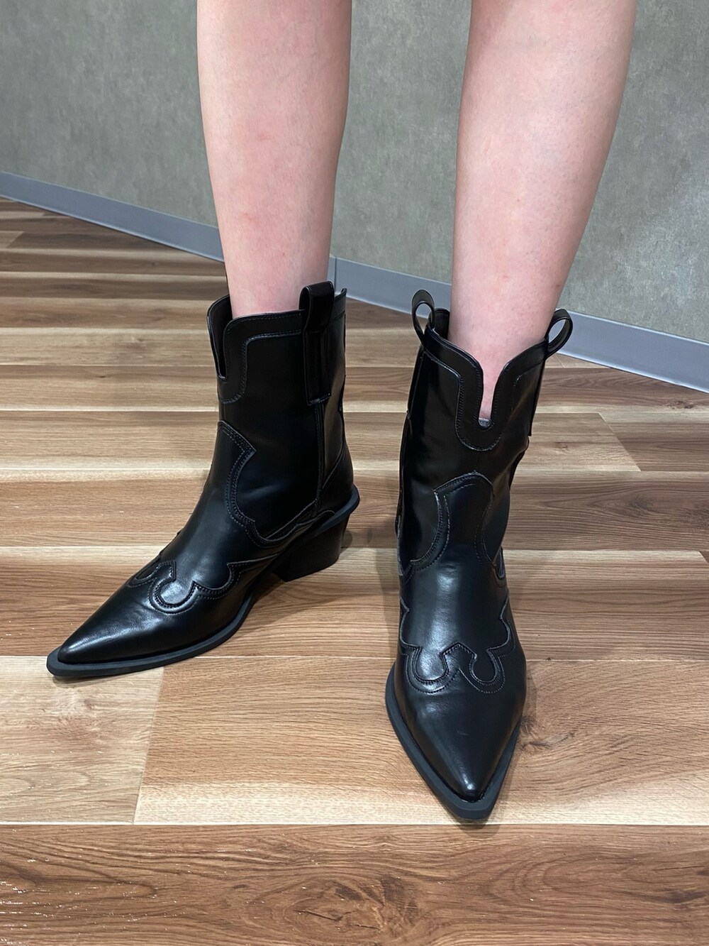 ブラック系のブーツ、ブラック系のワンピース、ブラック系のベルトを着用したレディースの春コーディネートの5枚目の写真