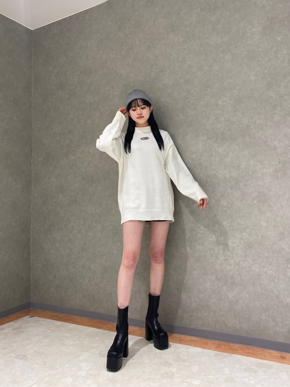 ブラック系のブーツ、グレー系のブルゾン、ホワイト系のニット/セーターを着用したレディースの冬コーディネートの2枚目の写真