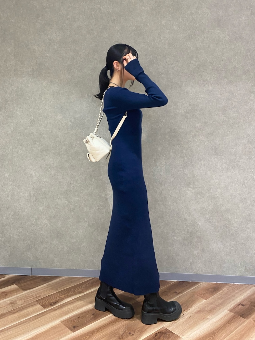 ブルー系のワンピース、ブラック系のブーツ、ホワイト系のバックパック/リュックを着用したレディースの秋コーディネートの2枚目の写真