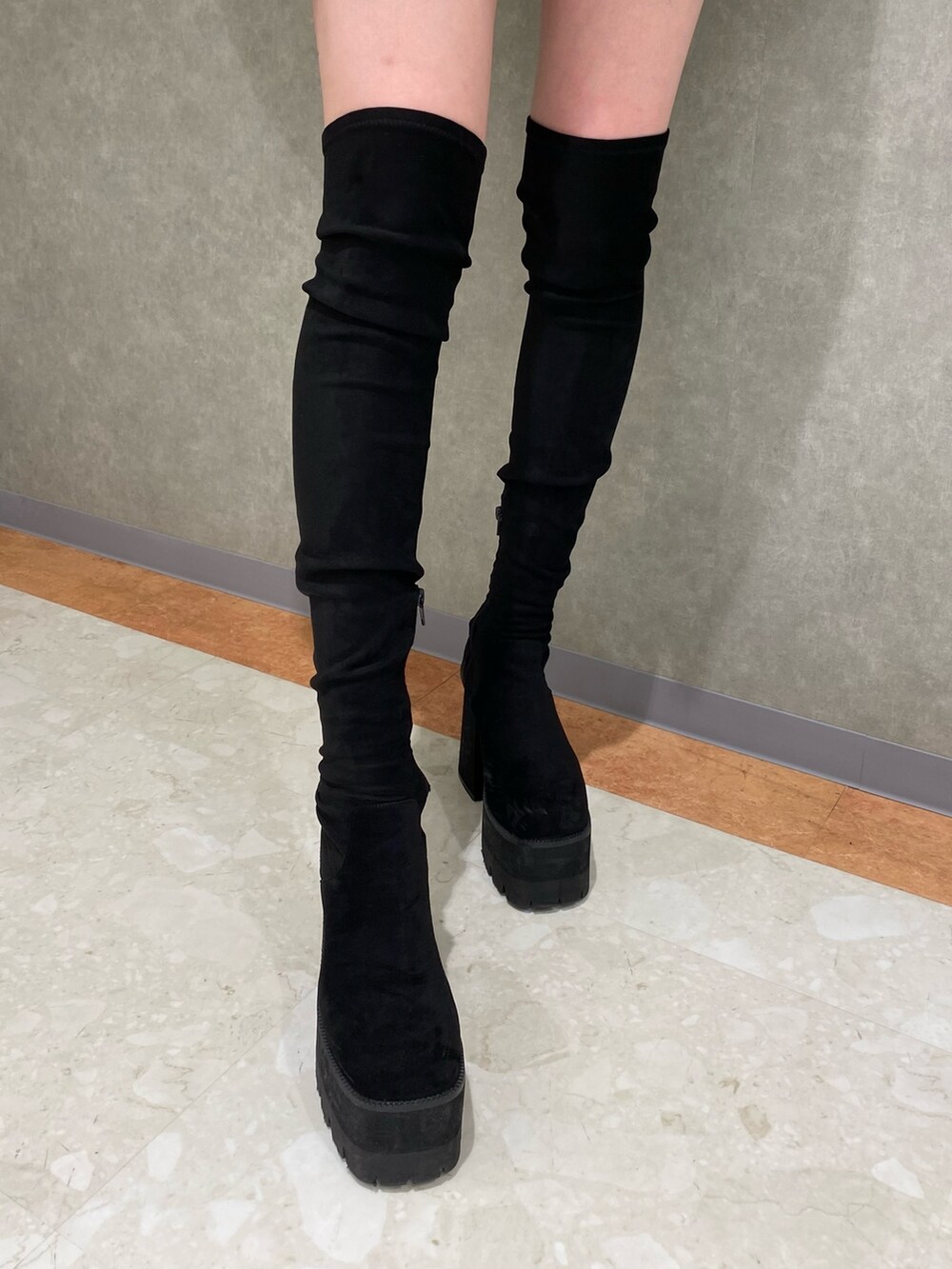 ブラック系のブーツ、ベージュ系のニット/セーター、その他のスカートを着用したレディースの秋コーディネートの6枚目の写真