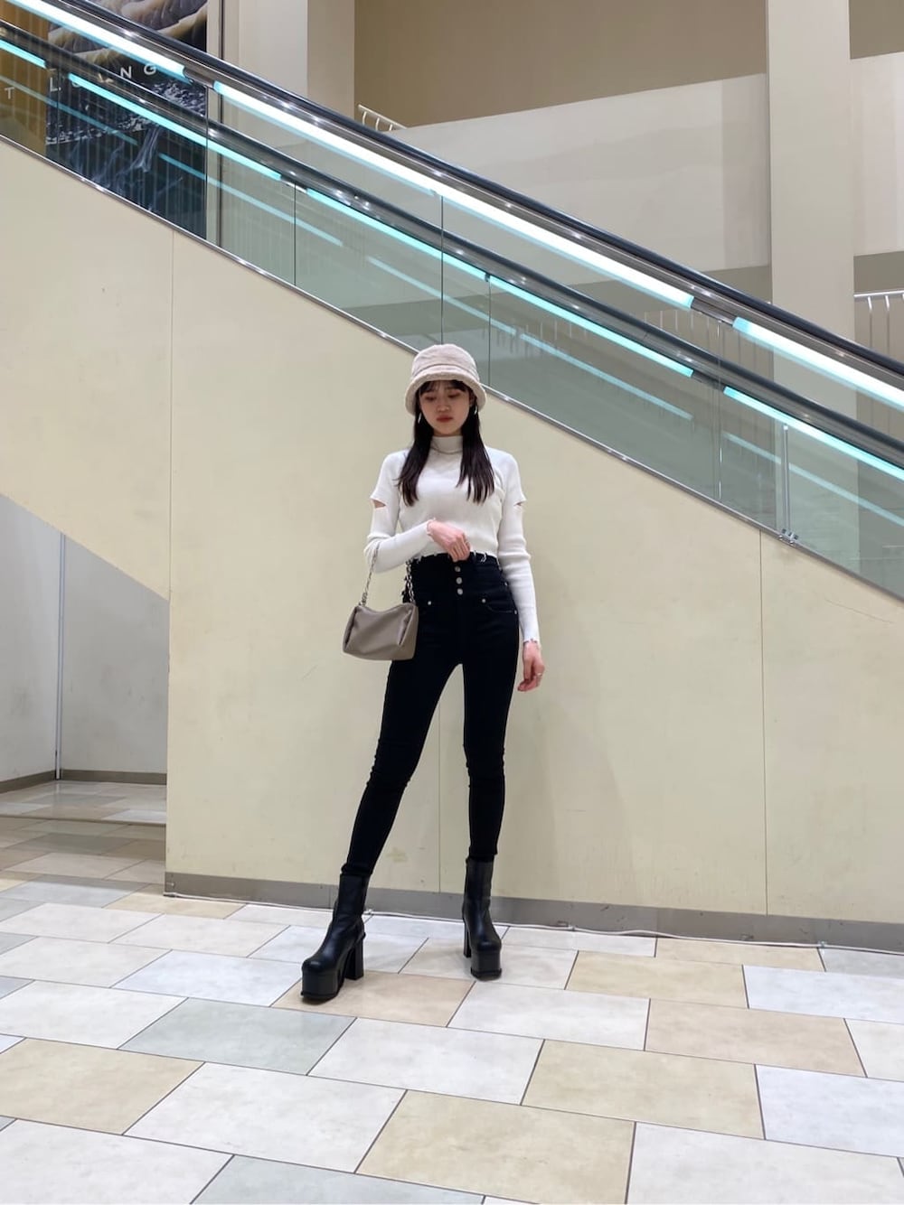 ベージュ系のハンドバッグ、ホワイト系のニット/セーター、ブラック系のデニムパンツを着用したレディースの秋コーディネートの3枚目の写真