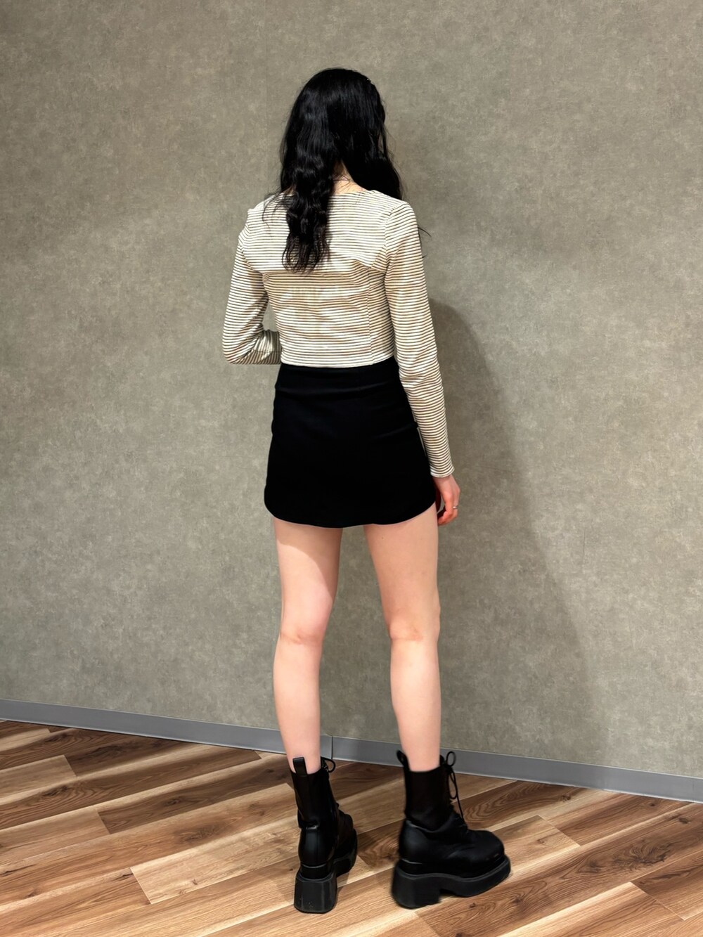 ブラック系のスカート、ブラック系のブーツ、その他のTシャツ/カットソーを着用したレディースの春コーディネートの3枚目の写真