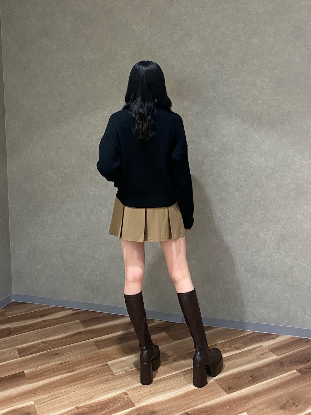 ブラウン系のブーツ、ベージュ系のスカート、ブラック系のニット/セーターを着用したレディースの冬コーディネートの3枚目の写真