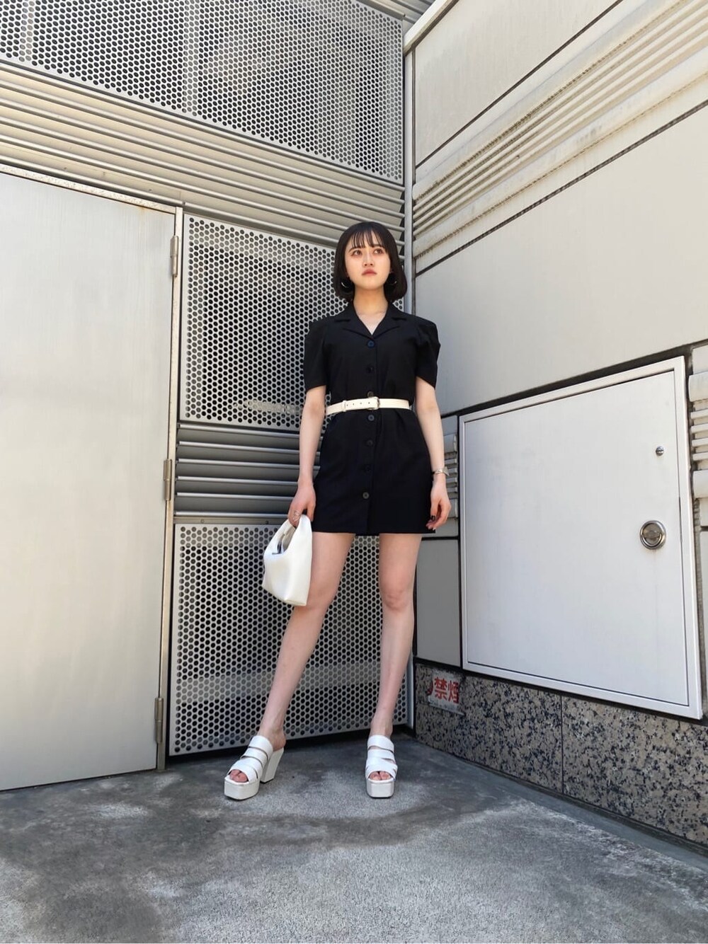 ホワイト系のサンダル、ブラック系のワンピース、ホワイト系のハンドバッグを着用したレディースの夏コーディネートの2枚目の写真