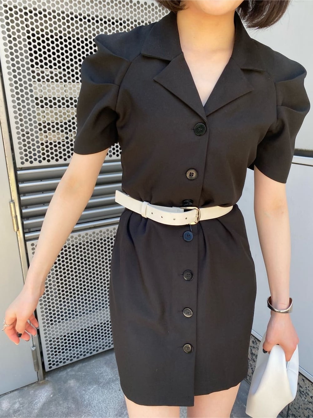 ホワイト系のサンダル、ブラック系のワンピース、ホワイト系のハンドバッグを着用したレディースの夏コーディネートの3枚目の写真