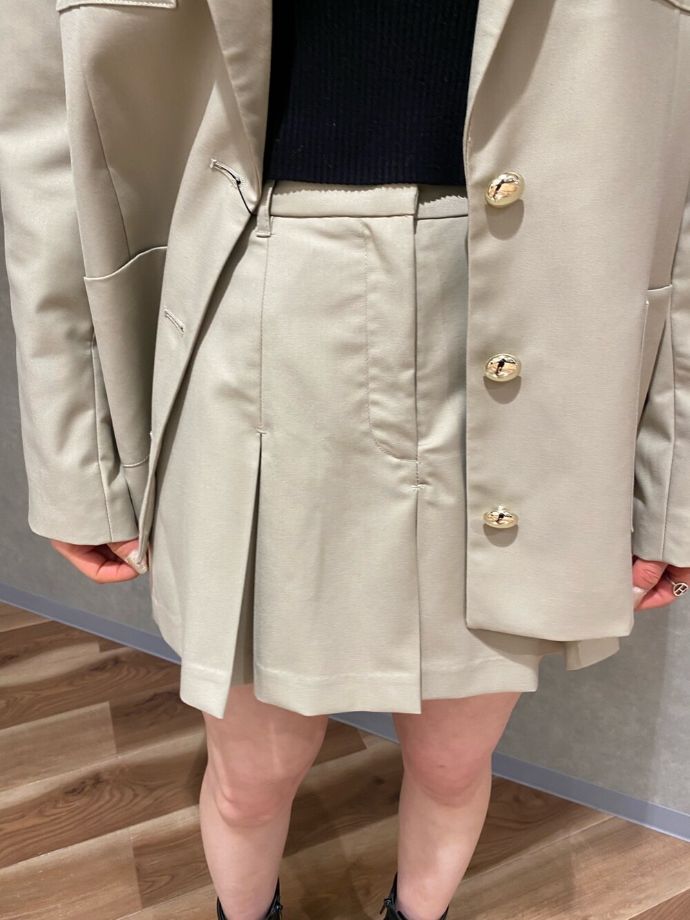 ベージュ系のテーラードジャケット、ブラック系のブーツ、ベージュ系のスカートを着用したレディースの冬コーディネートの6枚目の写真