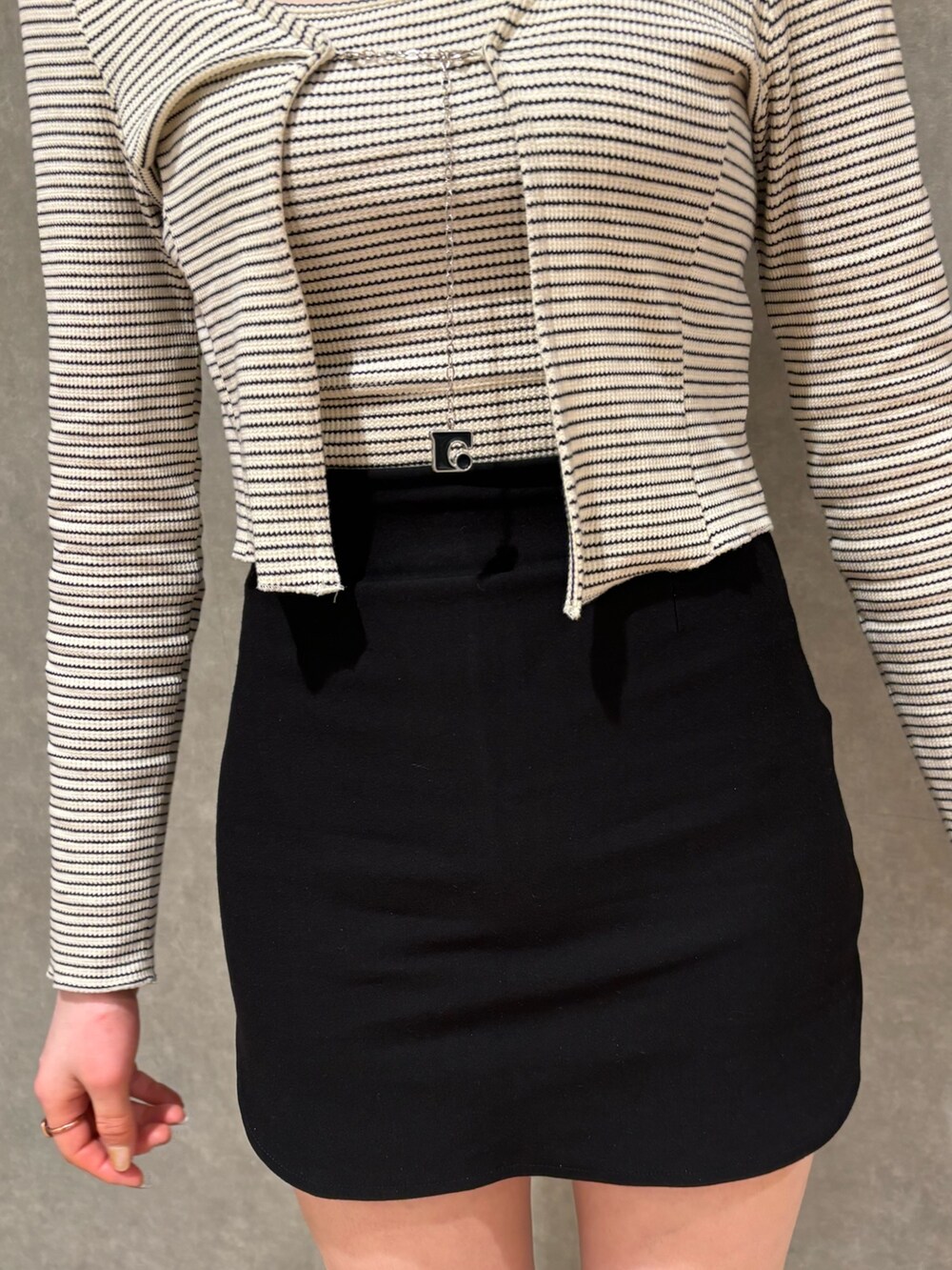 ブラック系のスカート、ブラック系のブーツ、その他のTシャツ/カットソーを着用したレディースの春コーディネートの5枚目の写真