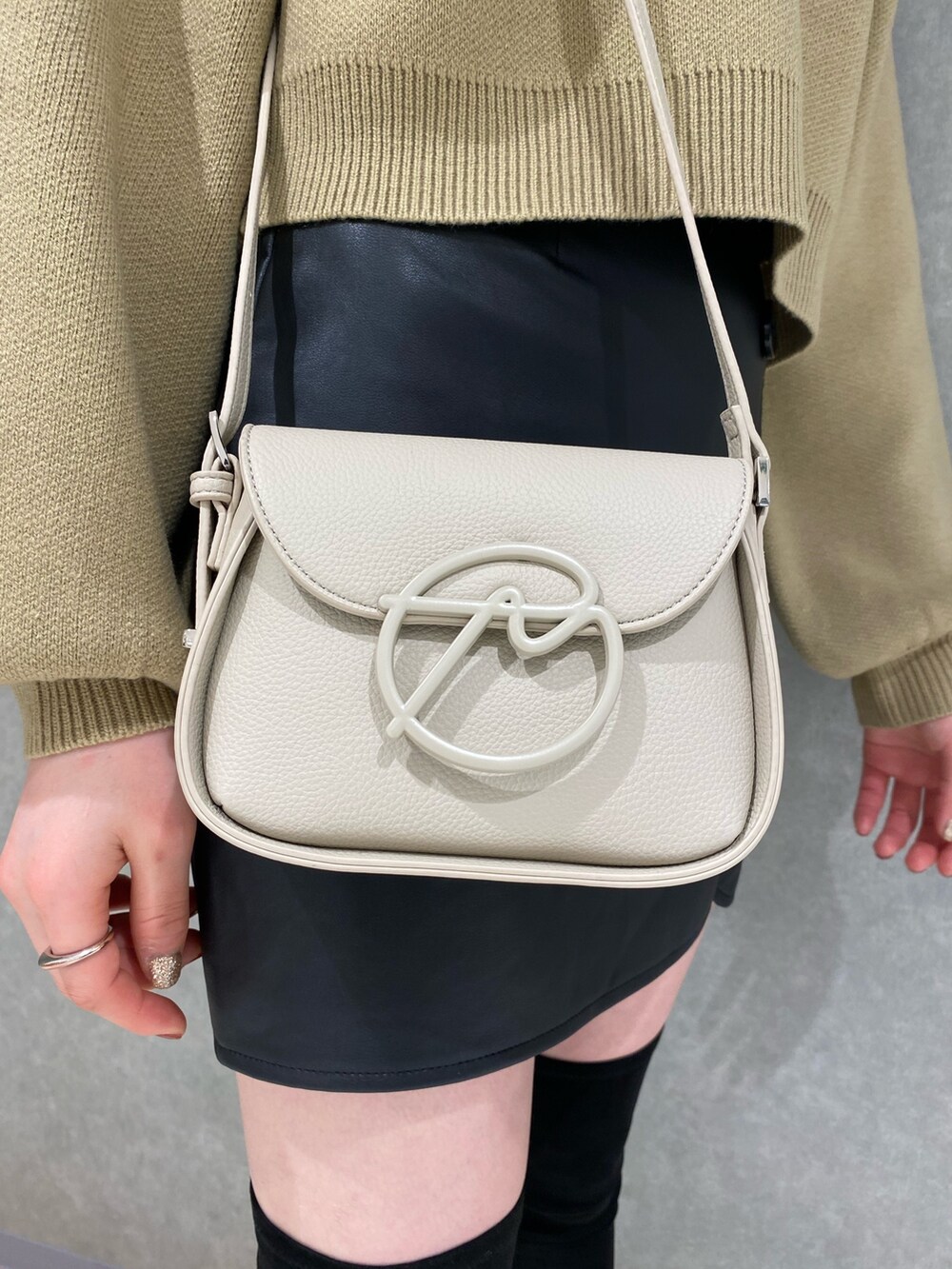 ブラック系のブーツ、ベージュ系のニット/セーター、その他のスカートを着用したレディースの秋コーディネートの5枚目の写真