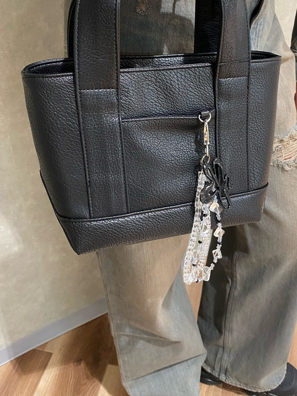 グレー系のデニムパンツ、ブラック系のスニーカー、ブラック系のハンドバッグを着用したレディースの冬コーディネートの7枚目の写真