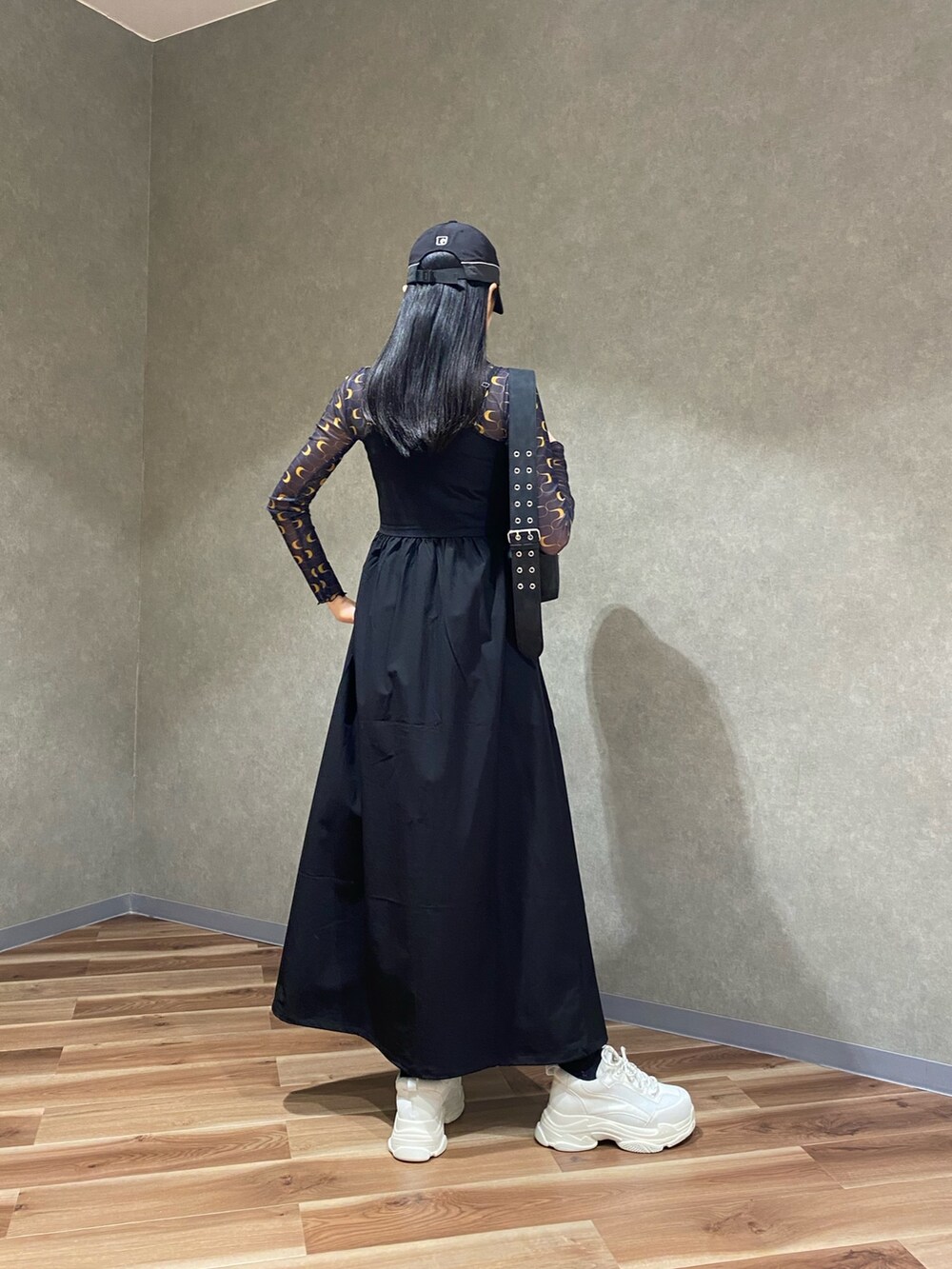 ブラック系のスニーカー、ブラック系のワンピース、ブラック系のショルダーバッグを着用したレディースの春コーディネートの3枚目の写真