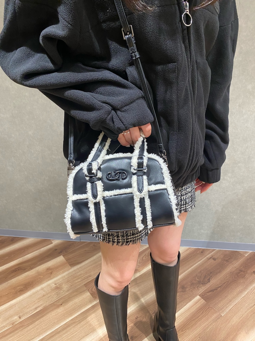 ブラック系のブルゾン、ブラック系のブーツ、ブラック系のハンドバッグを着用したレディースの秋コーディネートの5枚目の写真