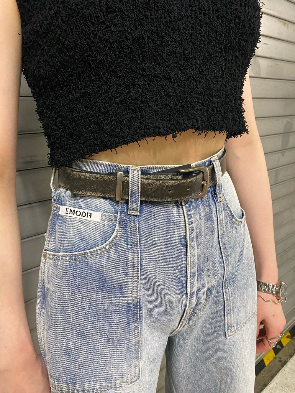 ブラック系のサンダル、ブラック系のニット/セーター、ブラック系のデニムパンツを着用したレディースの夏コーディネートの6枚目の写真