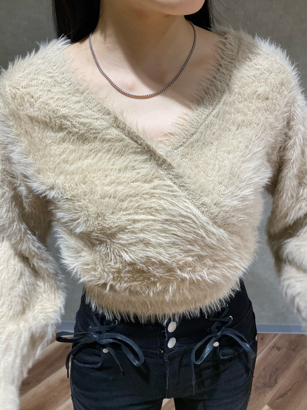 ブラック系のブーツ、ホワイト系のニット/セーター、ブラック系のデニムパンツを着用したレディースの冬コーディネートの3枚目の写真