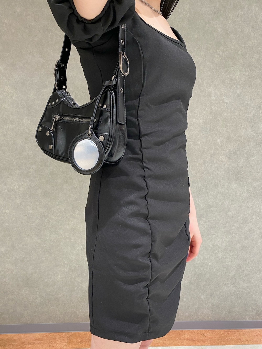 ホワイト系のデニムジャケット、ブラック系のハンドバッグ、ブラック系のサンダルを着用したレディースの春コーディネートの4枚目の写真