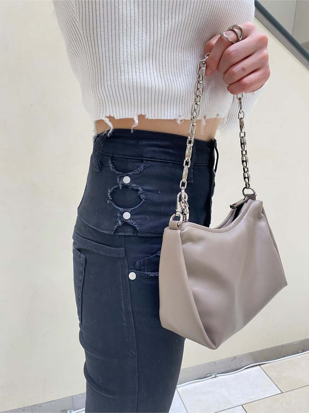 ベージュ系のハンドバッグ、ホワイト系のニット/セーター、ブラック系のデニムパンツを着用したレディースの秋コーディネートの5枚目の写真