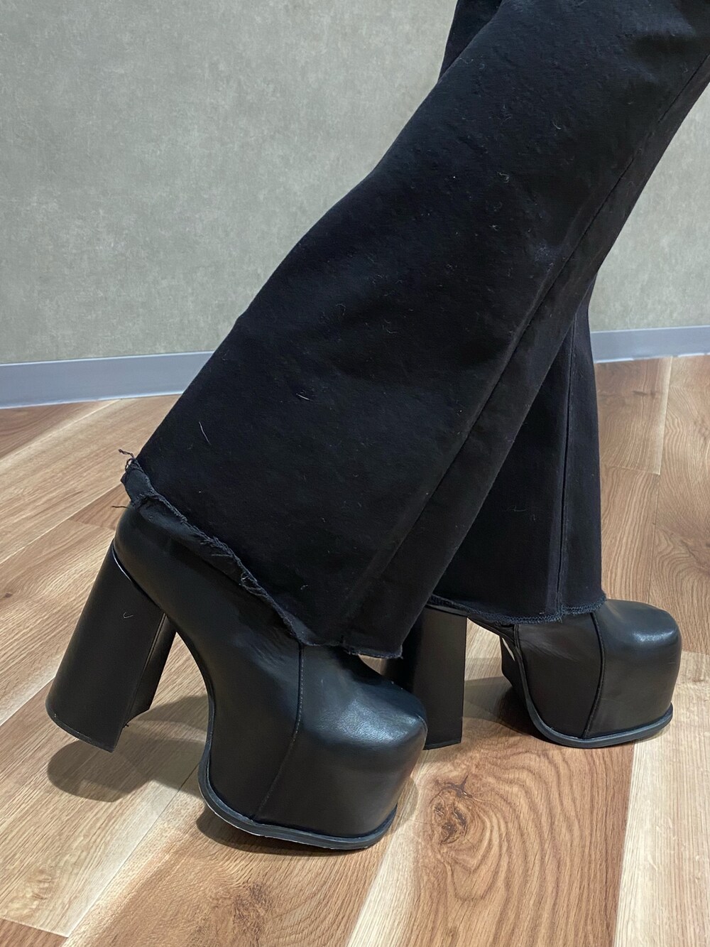 ブラック系のブーツ、ホワイト系のニット/セーター、ブラック系のデニムパンツを着用したレディースの冬コーディネートの4枚目の写真