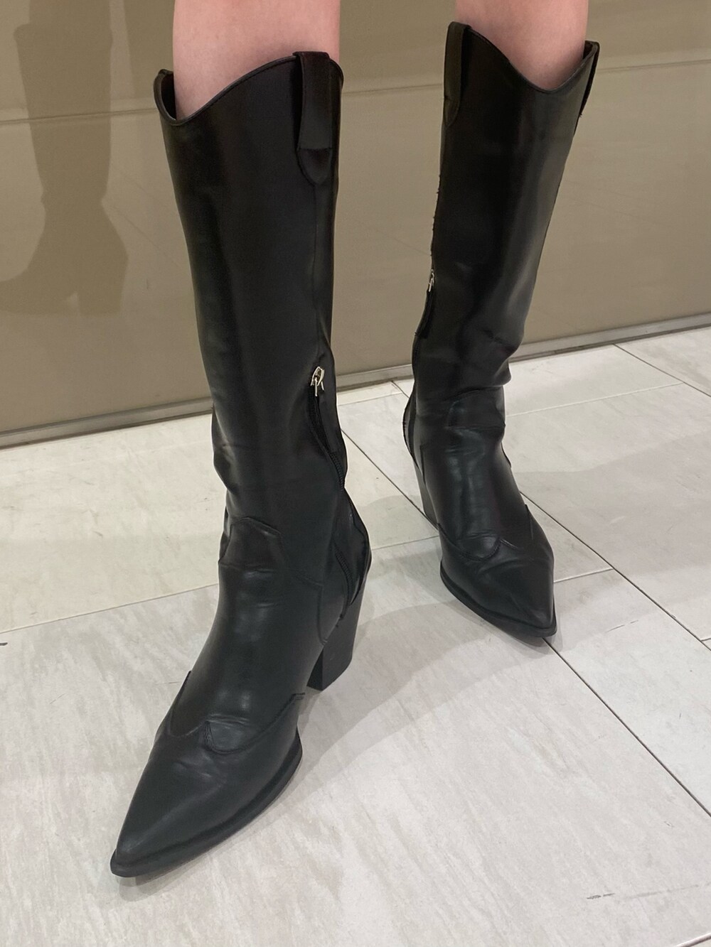 ブラック系のブーツ、ブルー系のワンピース、ブラック系のベルトを着用したレディースの春コーディネートの5枚目の写真