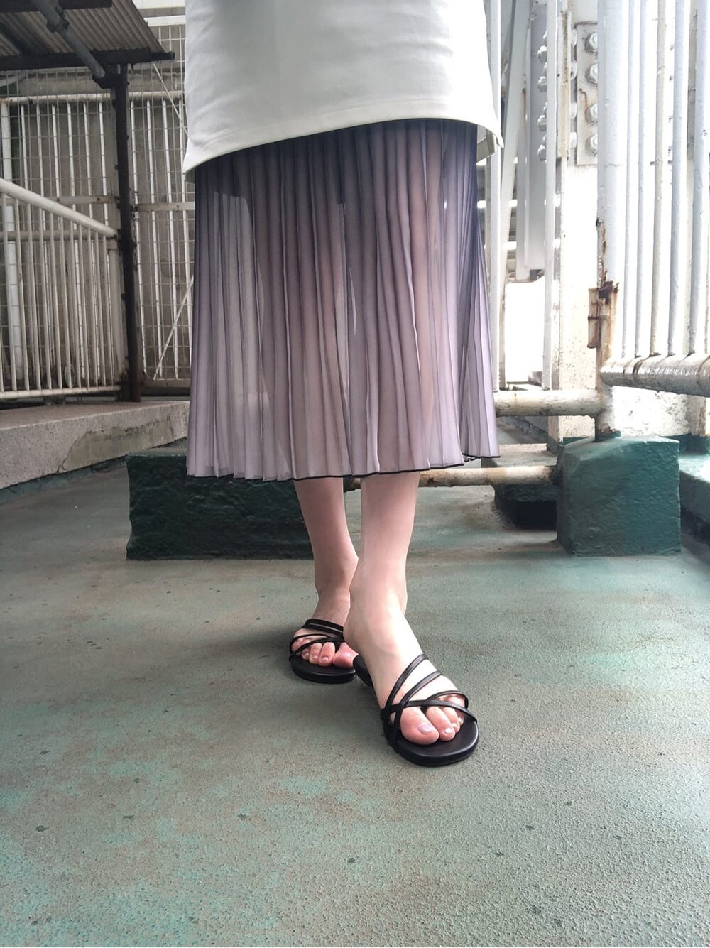 ホワイト系のワンピース、ブルー系のスカート、ブラック系のハンドバッグを着用したレディースの夏コーディネートの4枚目の写真