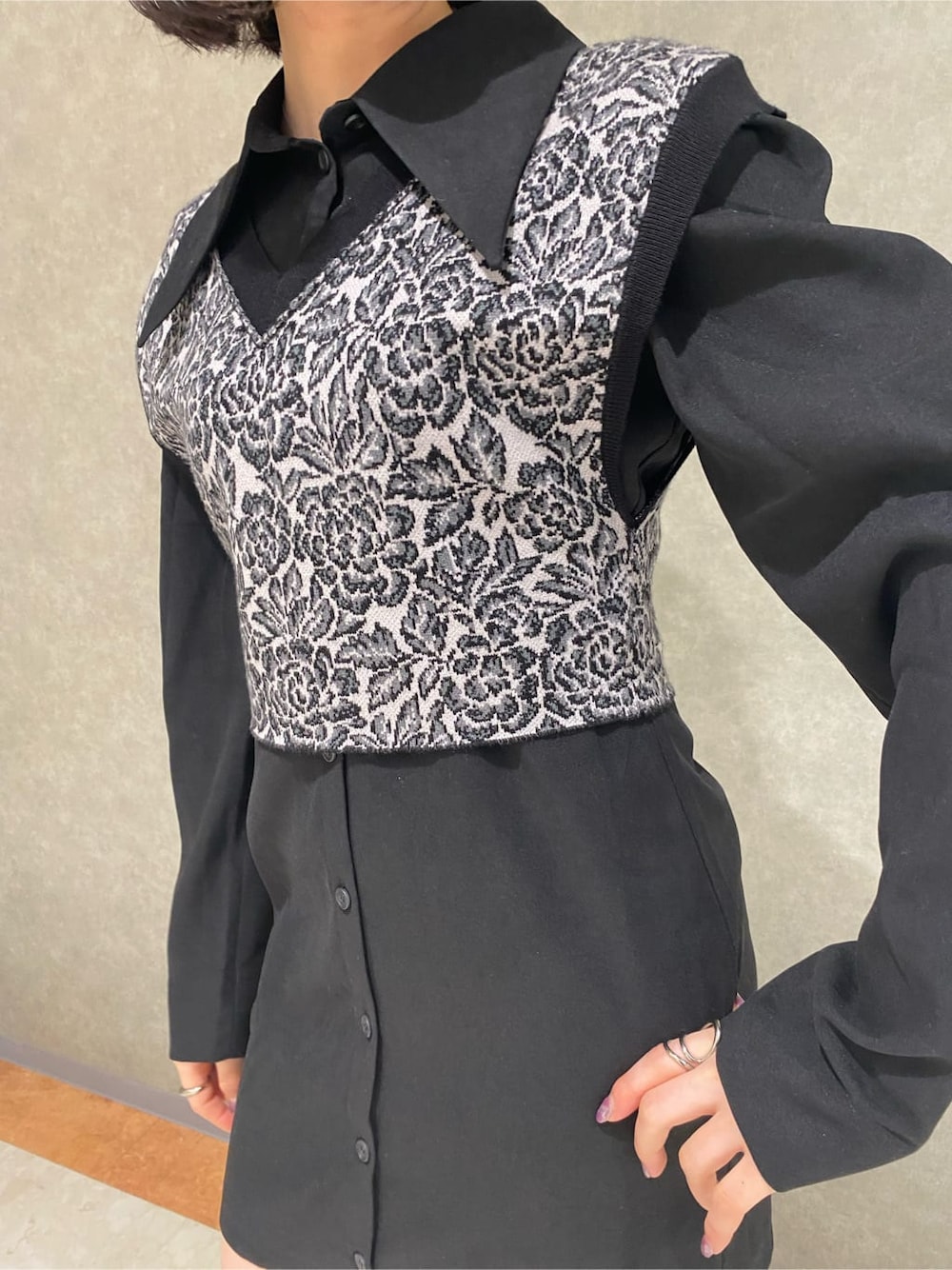 ブラック系のワンピース、ベージュ系のブーツ、その他のベストを着用したレディースの秋コーディネートの5枚目の写真