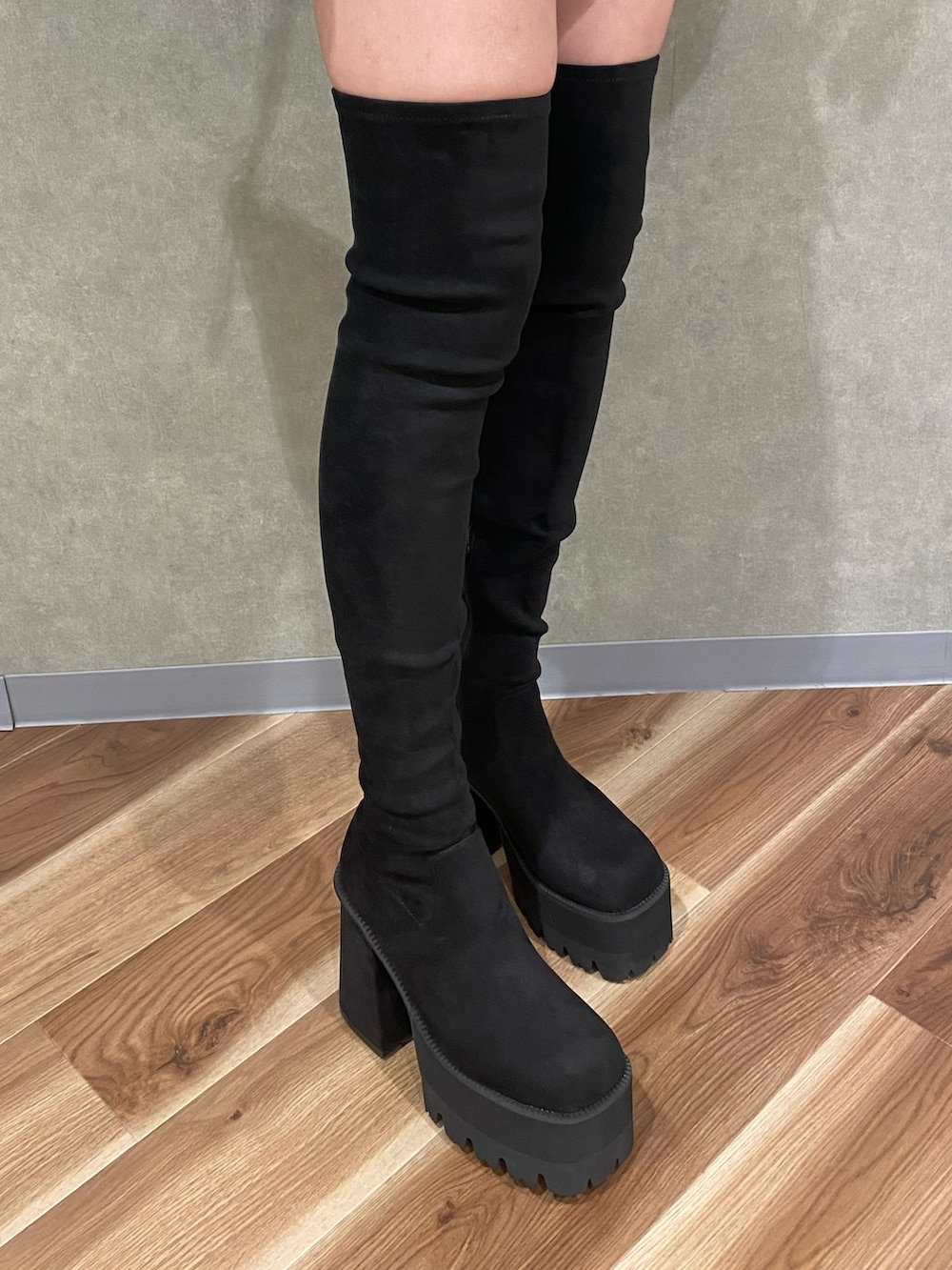 ブラック系のスカート、ホワイト系のハンドバッグ、ブラック系のブーツを着用したレディースの夏コーディネートの7枚目の写真