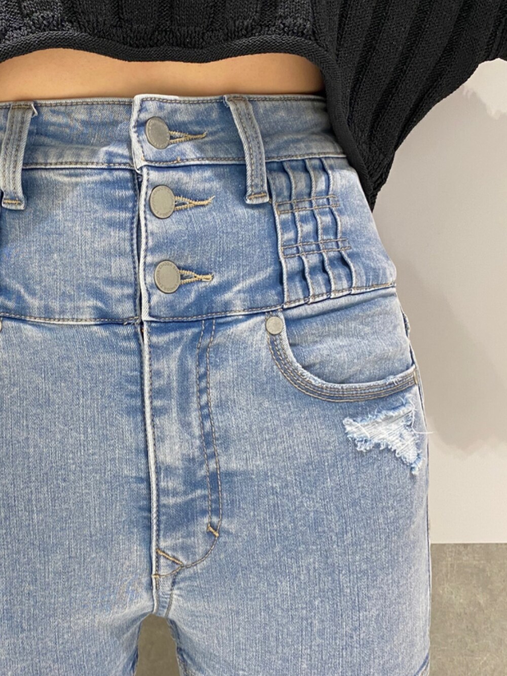 ブルー系のデニムパンツ、ブラック系のニット/セーター、シルバー系のパンプスを着用したレディースの冬コーディネートの5枚目の写真