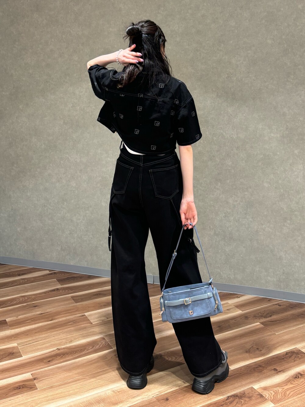 ブラック系のデニムパンツ、ブルー系のショルダーバッグ、ブラック系のサンダルを着用したレディースの夏コーディネートの3枚目の写真