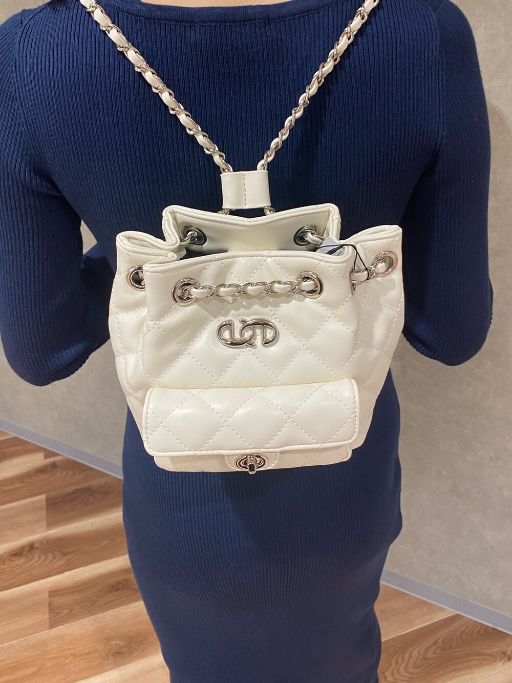 ブルー系のワンピース、ブラック系のブーツ、ホワイト系のバックパック/リュックを着用したレディースの秋コーディネートの6枚目の写真