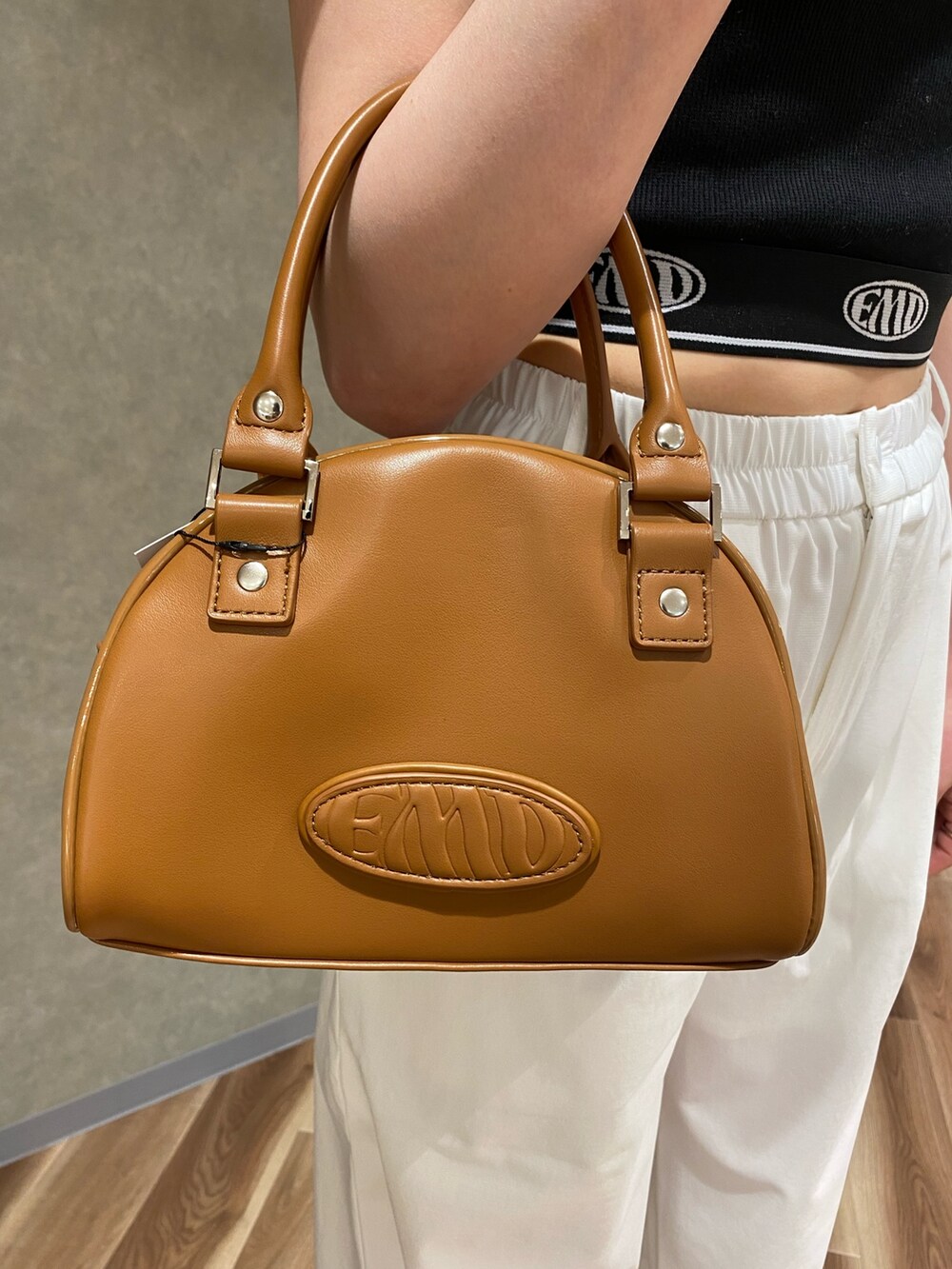 ホワイト系のその他パンツ、その他のハンドバッグ、ブラック系のブーツを着用したレディースの春コーディネートの5枚目の写真