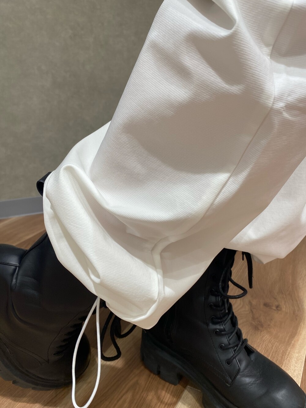 ホワイト系のその他パンツ、その他のハンドバッグ、ブラック系のブーツを着用したレディースの春コーディネートの6枚目の写真