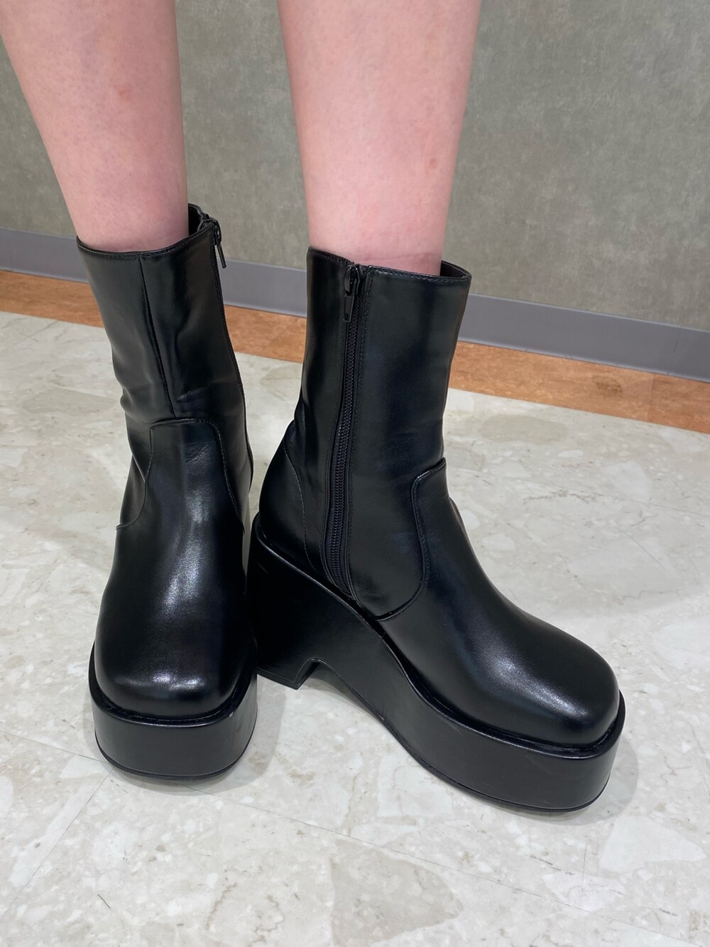 グレー系のワンピース、ブラック系のハンドバッグ、ブラック系のブーツを着用したレディースの春コーディネートの5枚目の写真