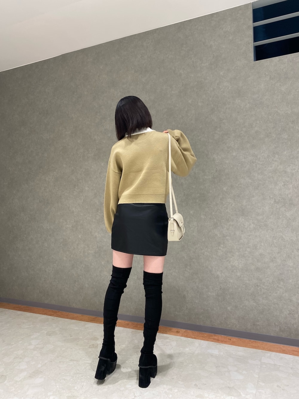 ブラック系のブーツ、ベージュ系のニット/セーター、その他のスカートを着用したレディースの秋コーディネートの2枚目の写真