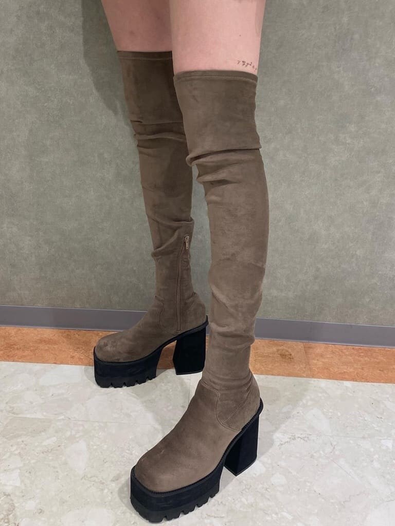 ブラック系のワンピース、ベージュ系のブーツ、その他のベストを着用したレディースの秋コーディネートの6枚目の写真