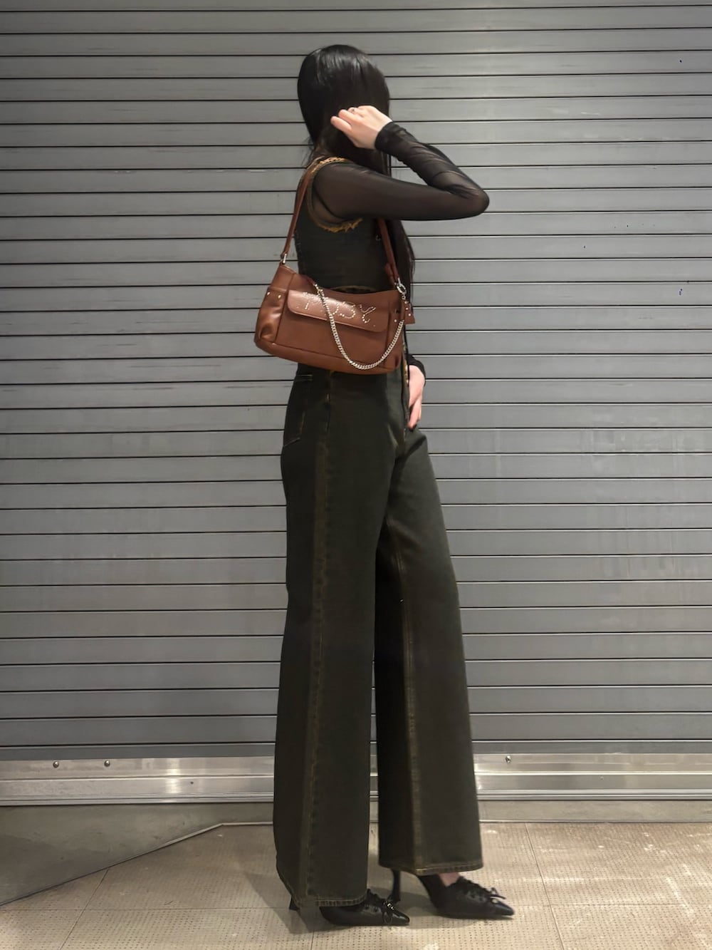 ブルー系のデニムパンツ、ブラウン系のハンドバッグ、ブルー系のタンクトップを着用したレディースの春コーディネートの2枚目の写真