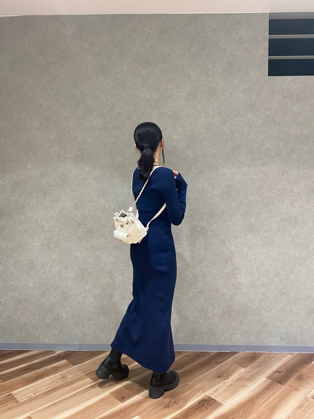 ブルー系のワンピース、ブラック系のブーツ、ホワイト系のバックパック/リュックを着用したレディースの秋コーディネートの3枚目の写真