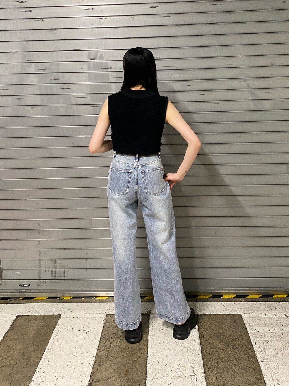 ブラック系のサンダル、ブラック系のニット/セーター、ブラック系のデニムパンツを着用したレディースの夏コーディネートの3枚目の写真