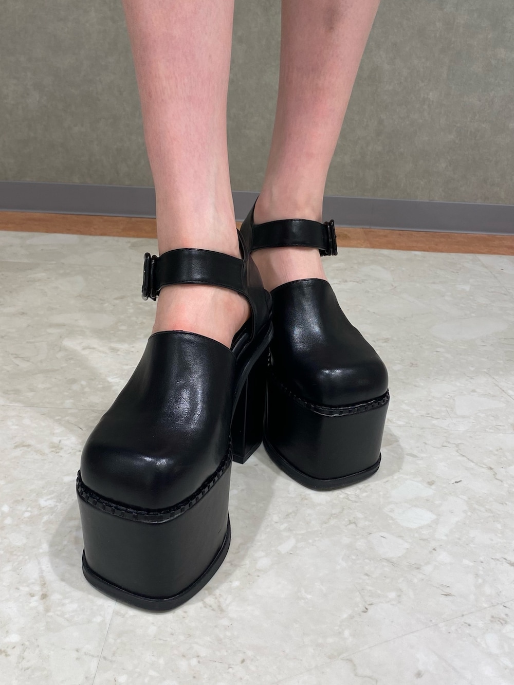 ホワイト系のデニムジャケット、ブラック系のハンドバッグ、ブラック系のサンダルを着用したレディースの春コーディネートの6枚目の写真