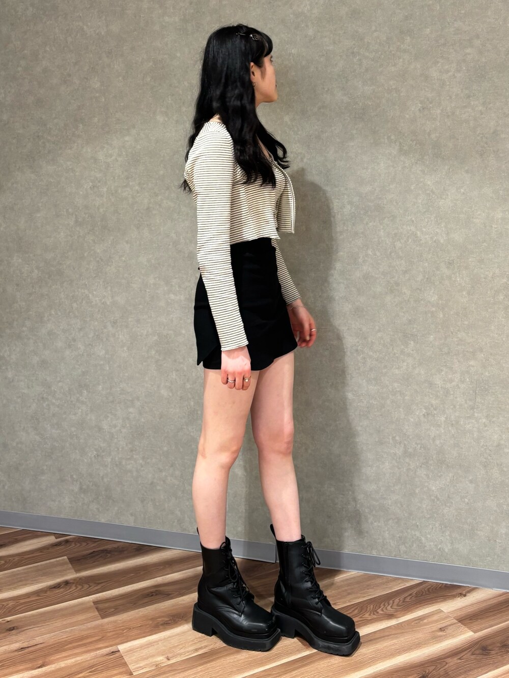 ブラック系のスカート、ブラック系のブーツ、その他のTシャツ/カットソーを着用したレディースの春コーディネートの2枚目の写真