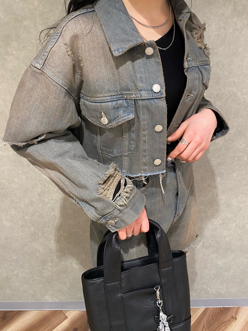 グレー系のデニムパンツ、ブラック系のスニーカー、ブラック系のハンドバッグを着用したレディースの冬コーディネートの5枚目の写真