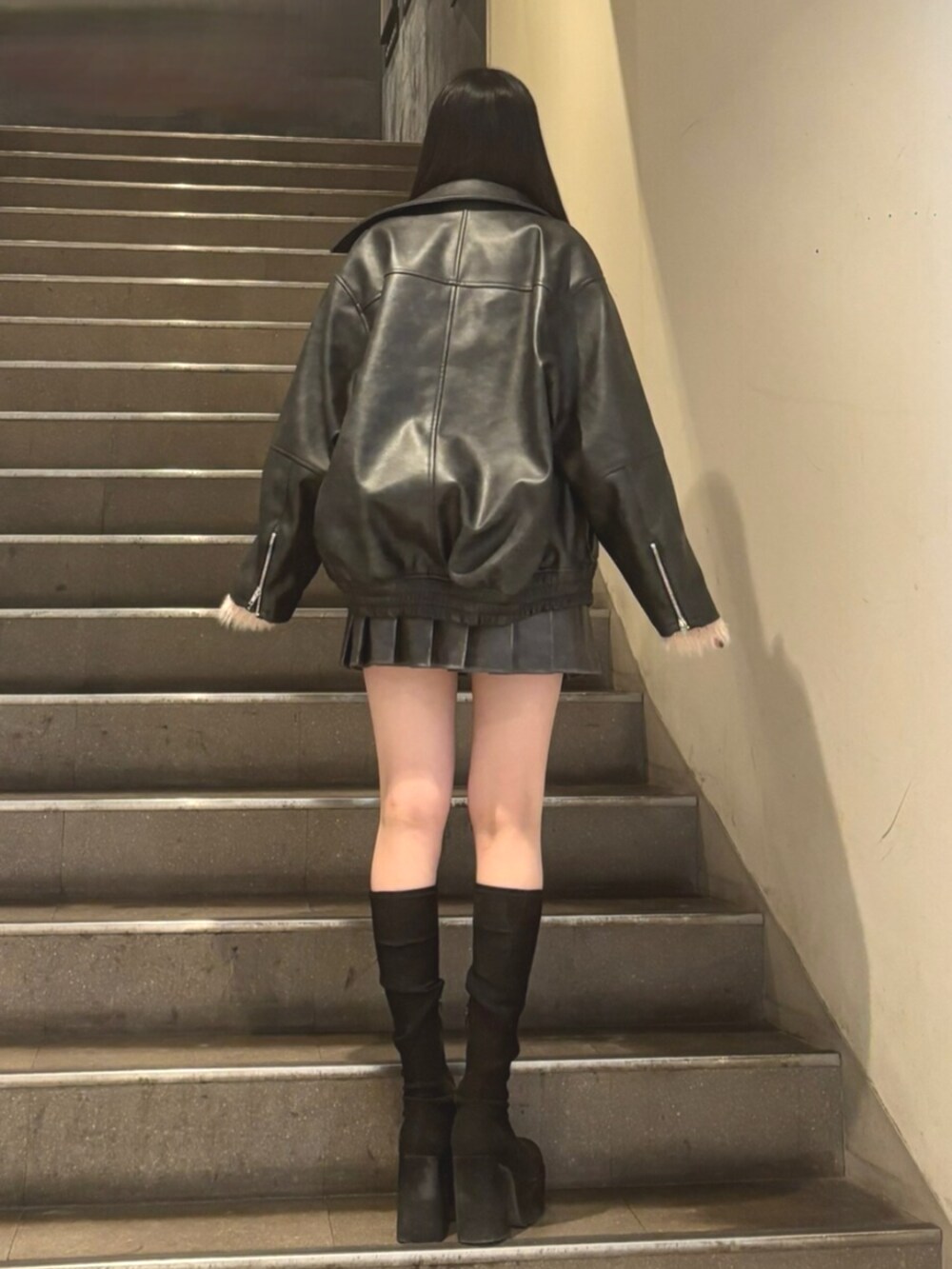 グレー系のスカート、その他のブーツ、ブラック系のブルゾンを着用したレディースの冬コーディネートの3枚目の写真