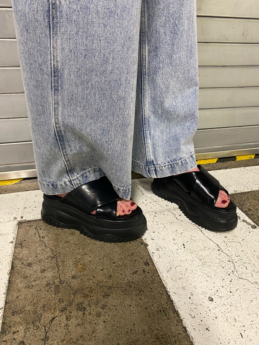 ブラック系のサンダル、ブラック系のニット/セーター、ブラック系のデニムパンツを着用したレディースの夏コーディネートの7枚目の写真