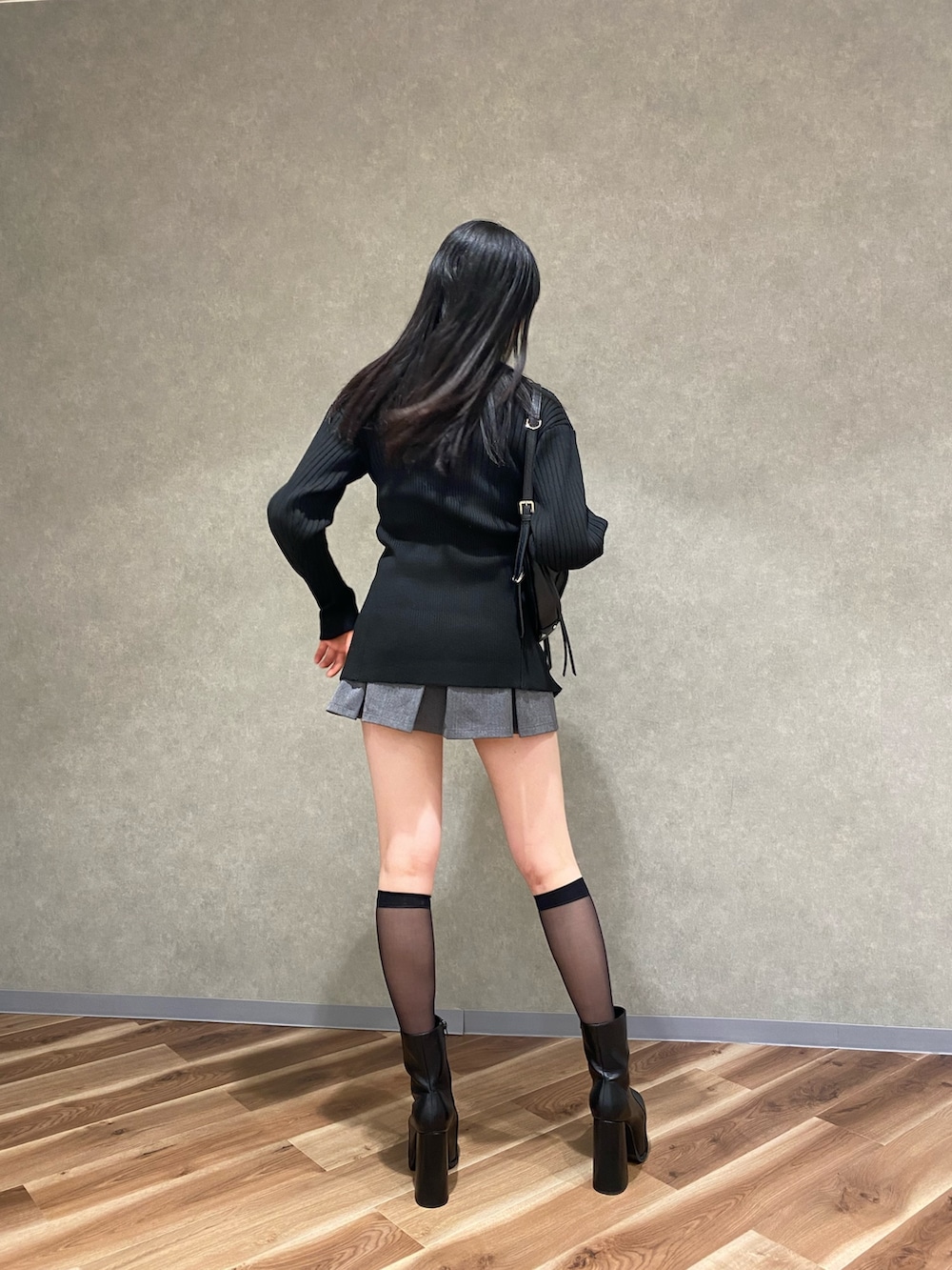 ベージュ系のスカート、ブラック系のブーツ、ブラック系のニット/セーターを着用したレディースの冬コーディネートの2枚目の写真