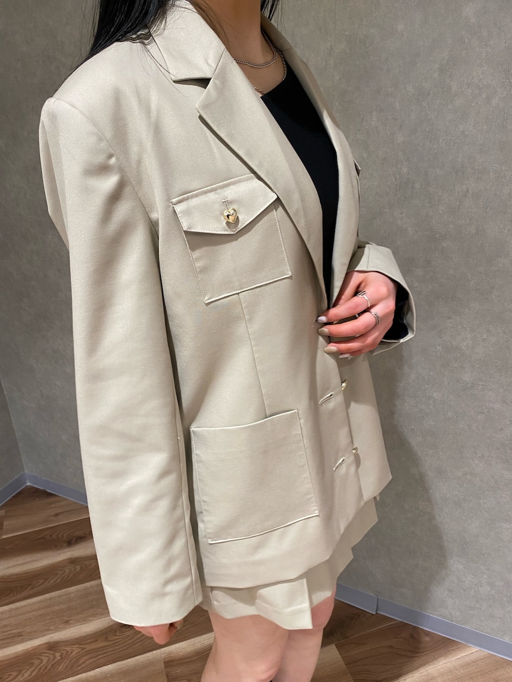 ベージュ系のテーラードジャケット、ブラック系のブーツ、ベージュ系のスカートを着用したレディースの冬コーディネートの5枚目の写真