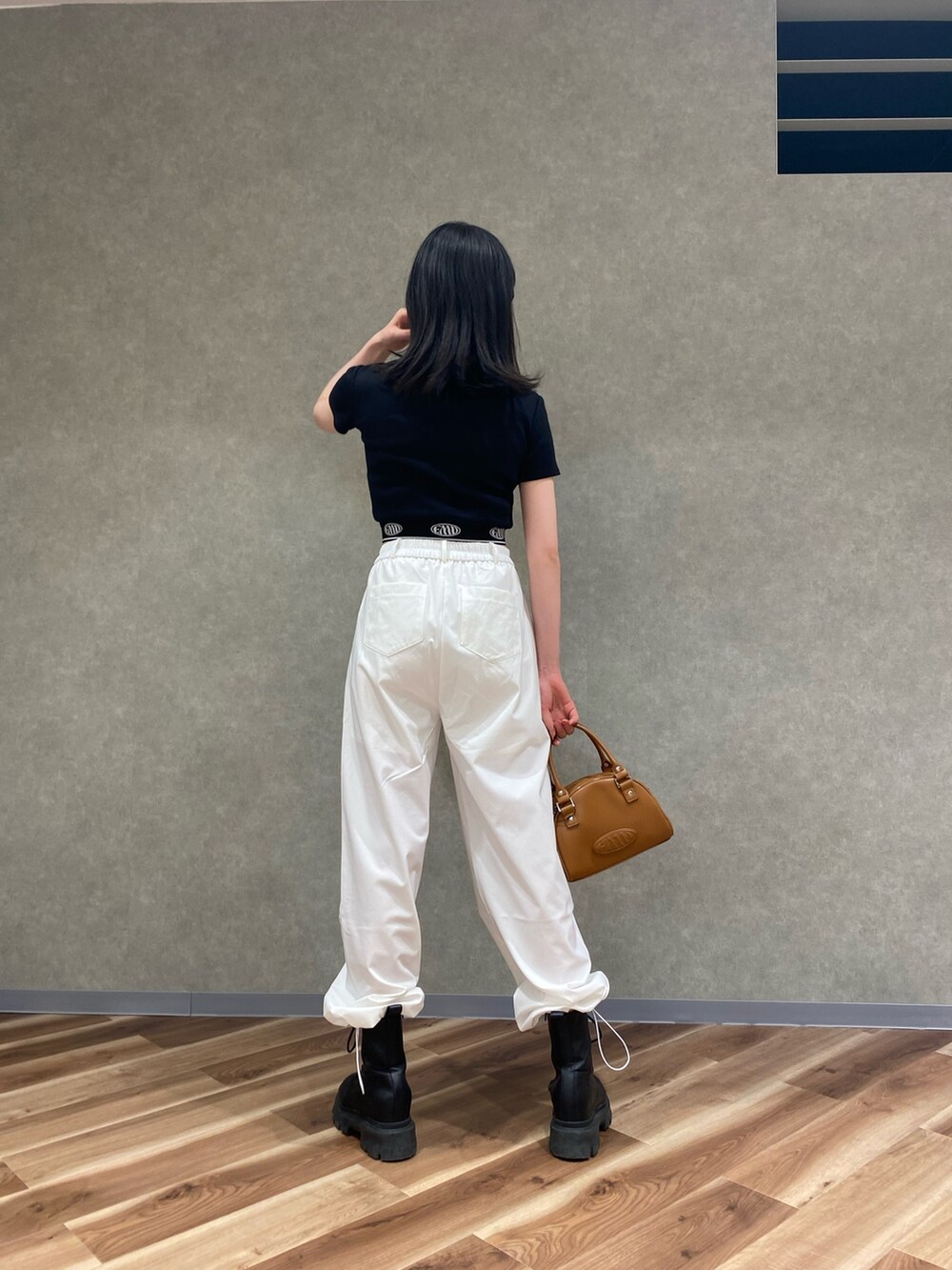 ホワイト系のその他パンツ、その他のハンドバッグ、ブラック系のブーツを着用したレディースの春コーディネートの3枚目の写真