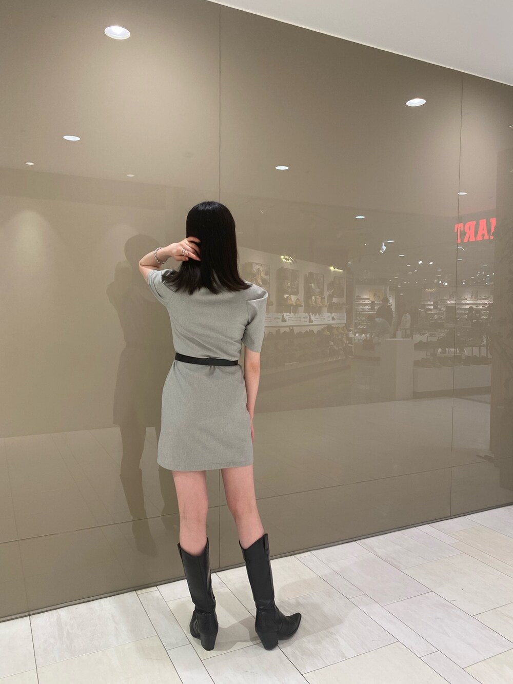 ブラック系のブーツ、ブルー系のワンピース、ブラック系のベルトを着用したレディースの春コーディネートの2枚目の写真